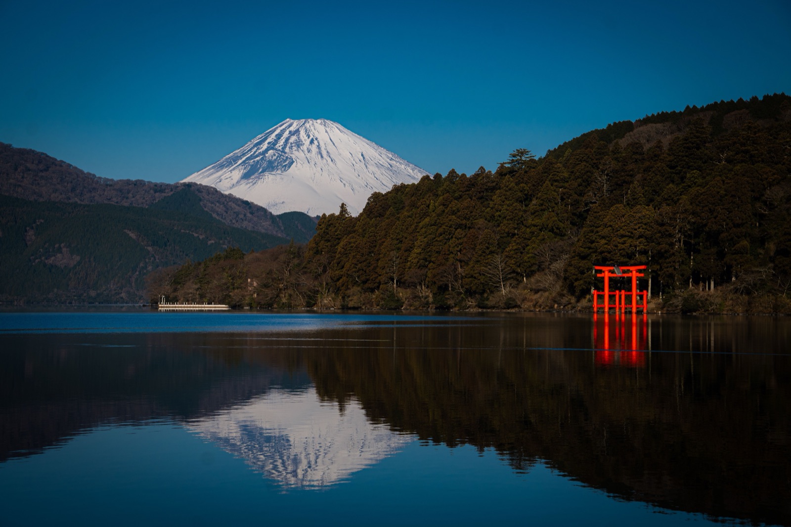 冠雪した富士山と箱根神社の鳥居が芦ノ湖に映る風景